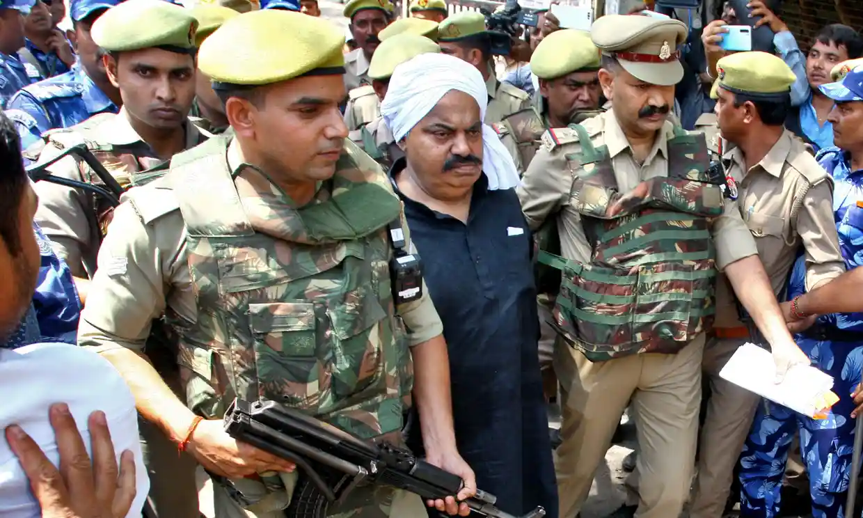 총격으로 사망한 아티크 아마드 전 인도 의원이 지난 13일 경찰의 호위를 받으며 법원을 나서고 있다. 프라야그라이 로이터 연합뉴스