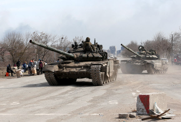 20일(현지시간) 우크라이나 동남부 마리우폴 외곽에서 친러시아 반군 탱크가 도로 위를 달리고 있다. 러시아군은 전략적 요충지인 항구도시 마리우폴을 장악하기 위한 공세를 강화하고 있다. 2022.3.21 로이터 연합뉴스