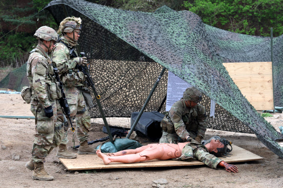 20일 경기도 포천시 로드리게즈 사격장에서 실시된 미2사단/한미연합사단 전문병사 휘장 시험 사전연습에서 미군 장병이 부상자를 치료하는 훈련을 하고 있다. 미2사단은 이달 28일까지 전문보병휘장, 전문야전의무병휘장, 전문병사휘장 시험을 진행한다. 2023.4.20 연합뉴스
