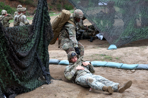 20일 경기도 포천시 로드리게즈 사격장에서 실시된 미2사단/한미연합사단 전문병사 휘장 시험 사전연습에서 미군 장병이 교전 중 발생한 부상자를 안전한 공간으로 대피시키는 훈련을 하고 있다. 미2사단은 이달 28일까지 전문보병휘장, 전문야전의무병휘장, 전문병사휘장 시험을 진행한다. 2023.4.20. 연합뉴스