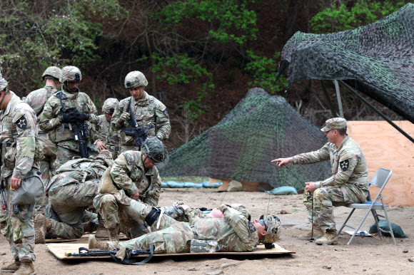 20일 경기도 포천시 로드리게즈 사격장에서 실시된 미2사단/한미연합사단 전문병사 휘장 시험 사전연습에서 미군 장병이 부상자를 치료하는 훈련을 하고 있다. 미2사단은 이달 28일까지 전문보병휘장, 전문야전의무병휘장, 전문병사휘장 시험을 진행한다. 2023.4.20 연합뉴스