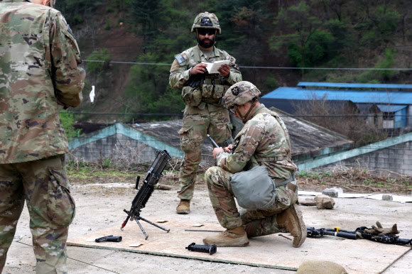 20일 경기도 포천시 로드리게즈 사격장에서 실시된 미2사단/한미연합사단 전문병사 휘장 시험 사전연습에서 미군 장병이 M249 경기관총을 분해 및 조립하는 훈련을 하고 있다. 미2사단은 이달 28일까지 전문보병휘장, 전문야전의무병휘장, 전문병사휘장 시험을 진행한다. 2023.4.20 연합뉴스