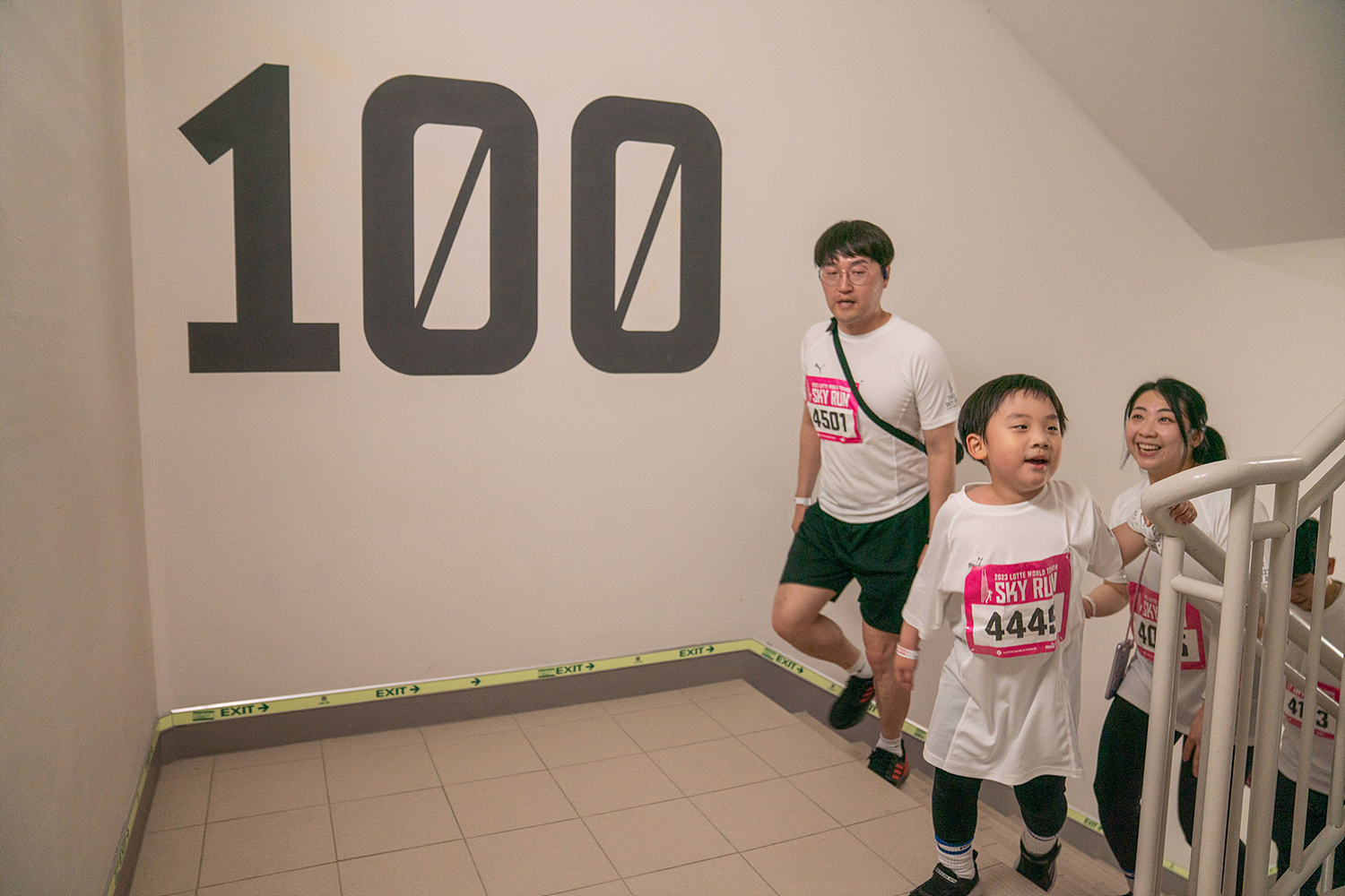 22일 서울 송파구 롯데월드타워에서 열린 ‘2023 스카이런’ 대회의 최연소 참가자 가족이 100층을 돌파하고 있다. 롯데물산 제공