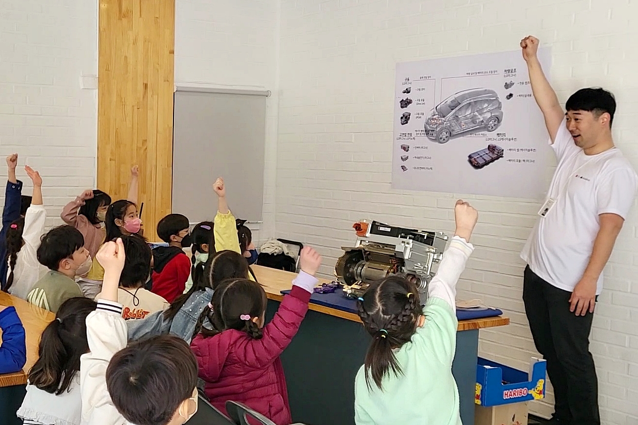 LG마그나 직원이 인천 서구 청람초등학교에서 LG마그나가 생산한 부품을 교구로 활용해 학생들에게 전기차에 대해 설명하고 있다.  LG마그나 제공