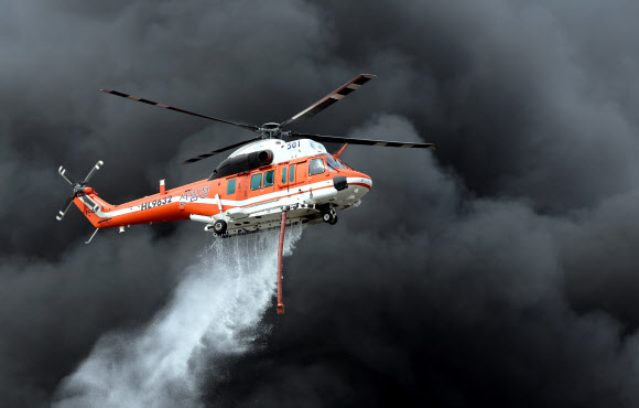 24일 오후 경기도 김포시 통진읍 옹정리 산업용 송풍기 제조공장 화재 현장 위에서 산림청 헬기가 물을 뿌리고 있다. 2023.4.24 연합뉴스