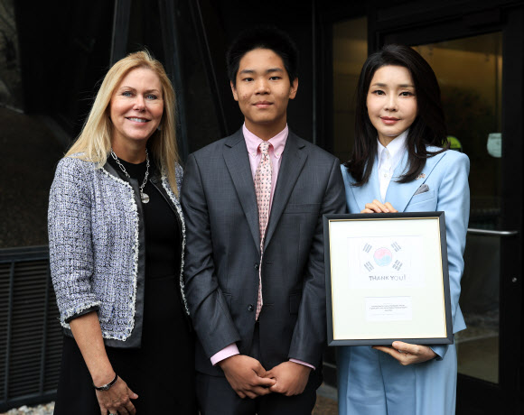 미국을 국빈 방문한 윤석열 대통령의 부인 김건희 여사가 25일(현지시간) 워싱턴DC 국립어린이 병원에서 열린 현대자동차의 ‘호프 온 휠스’ 특별후원 기념행사에 참석해 디엔 마샬 병원재단 이사장의 한인 입양 아들이 제작한 태극기 기념품을 선물받고 있다.  현대자동차 호프 온 휠스(Hope on Wheels)는 현대차 미국법인 및 판매회사들이 참여해 미국 전역의 소아암 연구에 매년 기부하는 프로그램이다. 2023.4.26. 공동취재