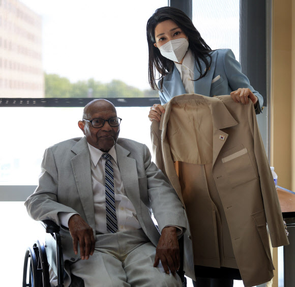 미국을 국빈 방문한 윤석열 대통령의 부인 김건희 여사가 25일(현지시간) 워싱턴DC 미 보훈요양원에서 한국전 참전용사인 로렌스 스프릭스 씨에게 제복을 선물하고 있다.   2023.4.26. 공동취재