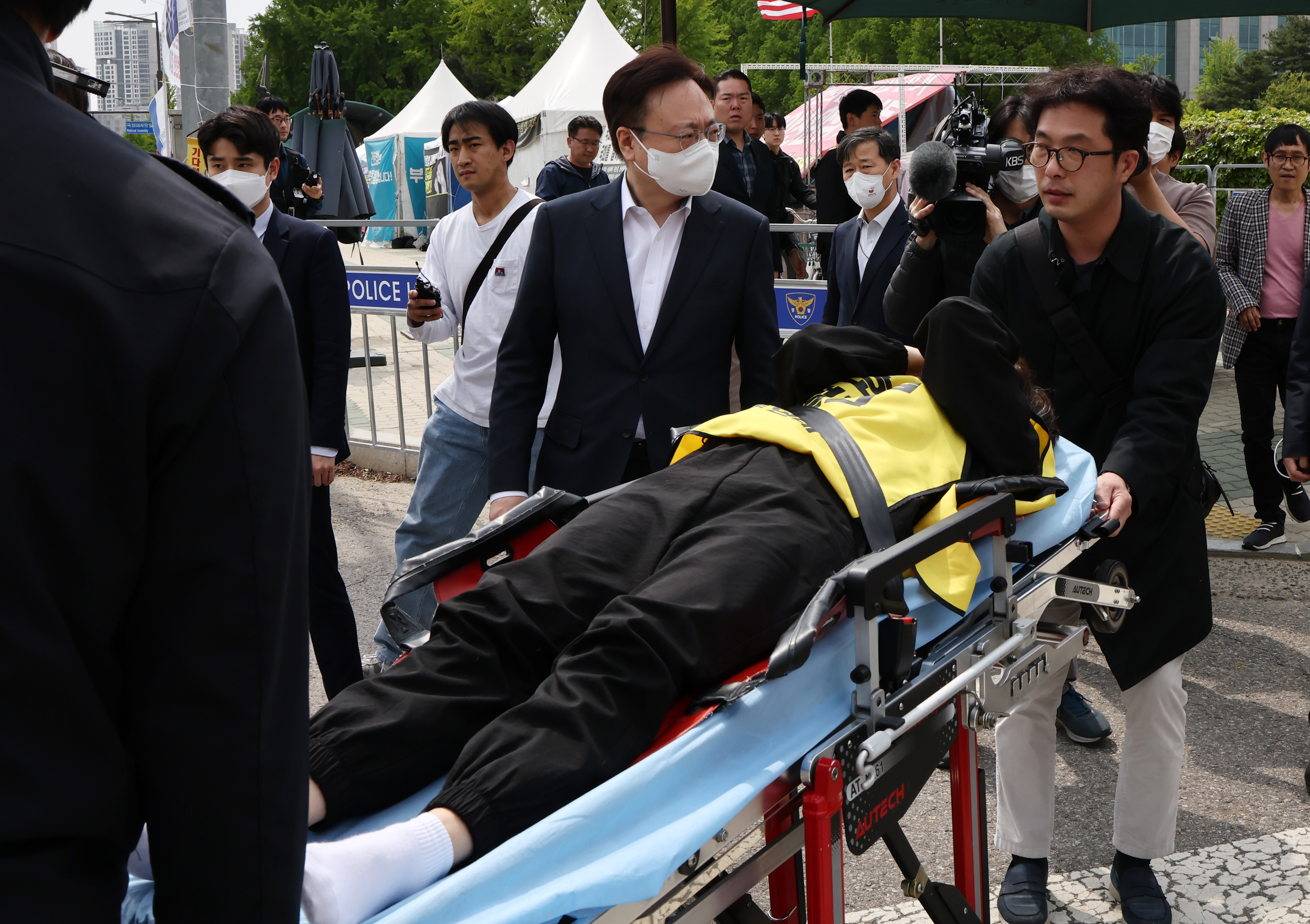 조규홍 보건복지부 장관이 30일 오후 국회 앞 천막 단식 중 건강이 악화돼 병원으로 이송되는 곽지연 대한간호조무사협회장과 함께 이동하고 있다. 연합뉴스