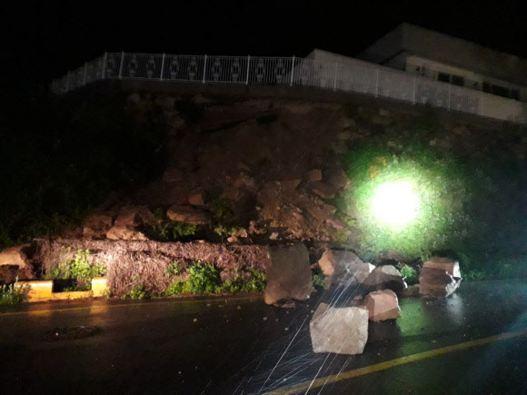 강풍을 동반한 많은 비가 내린 5일 오후 부산 금정구 비탈길에서 돌이 도로에 떨어져 있다. 기상청은 5일 부산에 강풍주의보와 호우주의보를 발효했다. 2023.5.6. 부산소방재난본부 제공