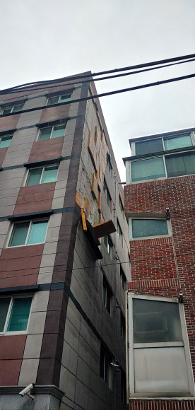 강풍을 동반한 많은 비가 내린 5일 오후 부산 연제구에서 건물 외벽이 떨어지려 하고 있다. 기상청은 5일 부산에 강풍주의보와 호우주의보를 발효했다. 2023.5.6. 부산소방재난본부 제공