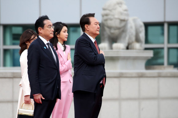 윤석열 대통령과 김건희 여사가 7일 서울 용산 대통령실에서 열린 일본 기시다 총리 공식 환영식에서 국기에 경례하는 동안, 기시다 총리 부부가 의장대를 지켜보고 있다.  2023.5.7 연합뉴스