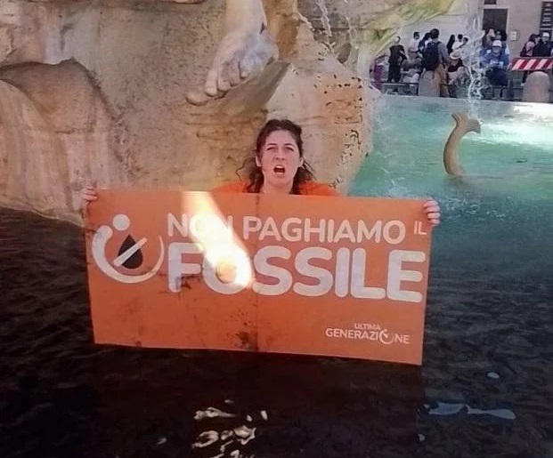이탈리아 환경단체 ‘울티마 제네라치오네’ 활동가가 지난 6일(현지시간) 로마 피우미 분수에 ‘먹물 테러’를 한 뒤 “우리의 미래는 이 물처럼 어둡다”고 쓰인 손팻말을 들고 있다. 울티마 제네라치오네 홈페이지 캡처