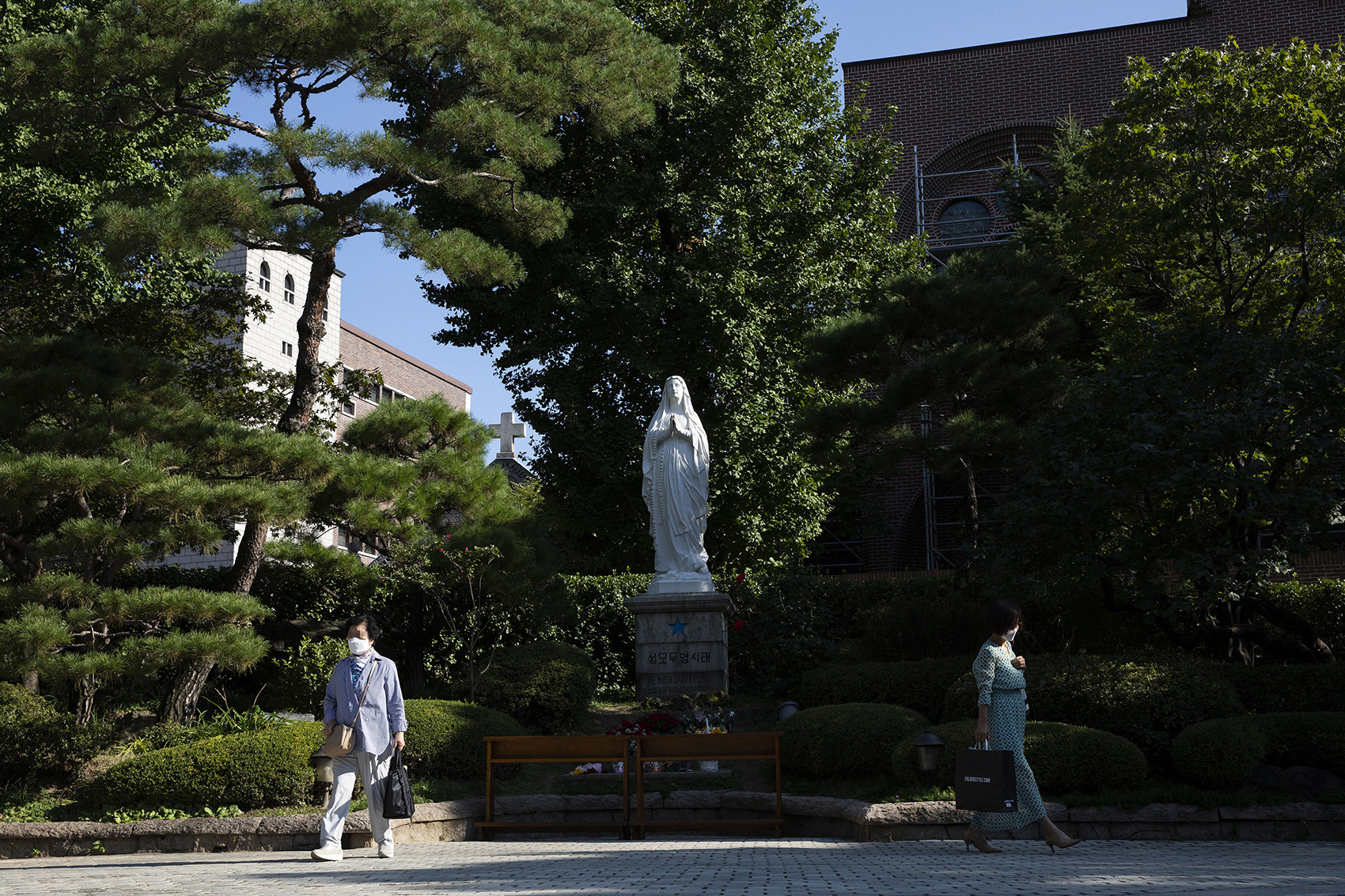 2020년 9월 20일 서울 중구 명동성당 성모 마리아 동상 앞에서 두 여성이 기도를 한 후 이동하고 있다. 2020.9.20 홍윤기 기자