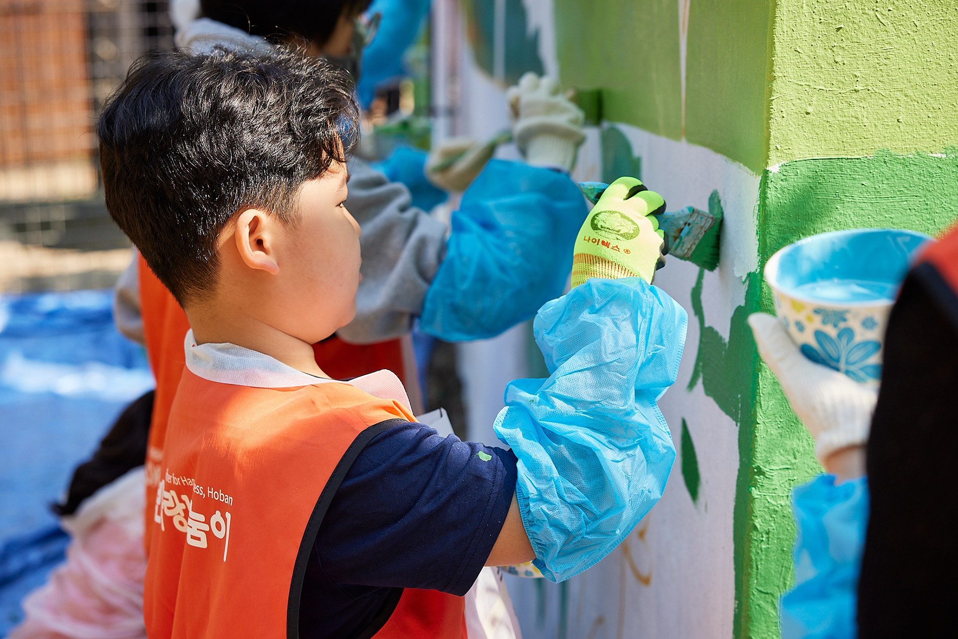 호반그룹 임직원 한 자녀가 가족과 함께 서울대공원 벽화 그리기 봉사활동을 하고 있다. 호반그룹 제공