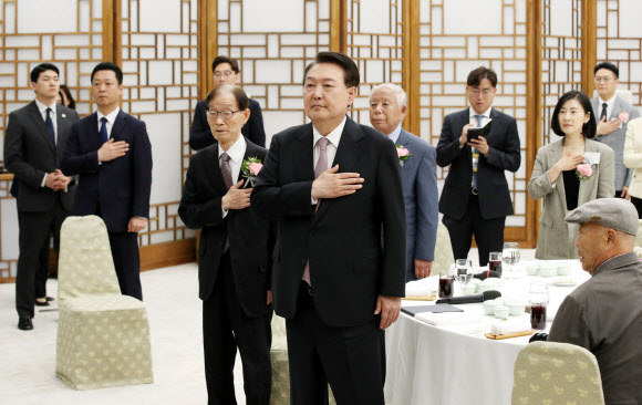 윤석열 대통령이 15일 서울 용산 대통령실 청사에서 열린 제42회 스승의 날 기념 현장교원 초청 오찬 간담회에서 국기에 경례하고 있다. 2023.5.15 대통령실통신사진기자단