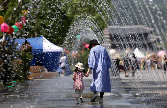때이른 여름 날씨를 보이는 17일 오후 서울 광화문광장에서 시민들이 분수 터널을 지나고 있다. 2023.5.17 연합뉴스