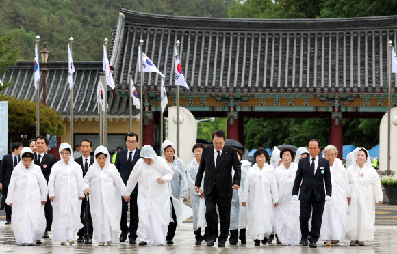 윤석열 대통령이 18일 광주 북구 국립5·18민주묘지에서 열린 제43주년 5·18민주화운동 기념식에 오월어머니회 회원들과 함께 입장하고 있다. 2023.5.18 연합뉴스