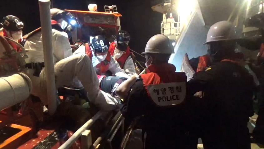 손목을 크게 다친 중국 선원을 응급조치 후 긴급 후송중인 해양경찰.[해양경찰청 제공]