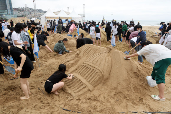 19일 ‘2023 해운대 모래축제’가 개막한 부산 해운대해수욕장에서 시민들이 모래작품을 제작하는 체험을 하고 있다. 해운대 모래 축제는 22일까지 2030 미래를 향한 엑스포 모래바다를 주제로 해운대해수욕장과 구남로 해운대 광장 일대에서 열린다. 2023.5.19 연합뉴스