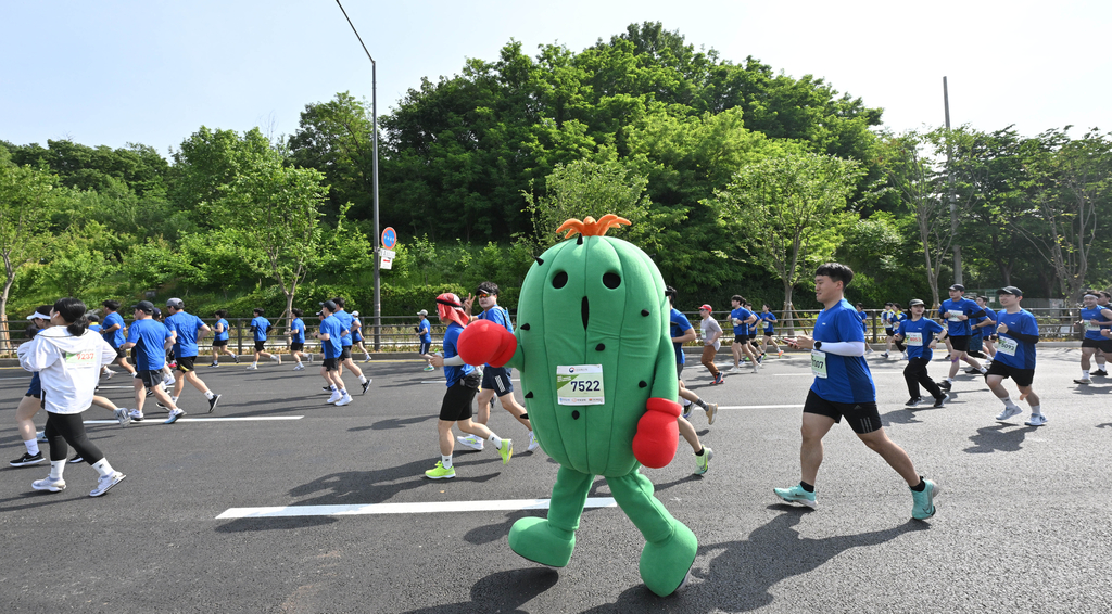 20일 서울 마포구 성산동 ‘2023 서울신문 하프마라톤 대회’ 10㎞ 코스에 참가한 애니메이션 캐릭터인 ‘니드몬’ 인형 탈을 쓴 참가자가 다른 선수들과 함께 달리고 있다.
2023.5.20 홍윤기 기자