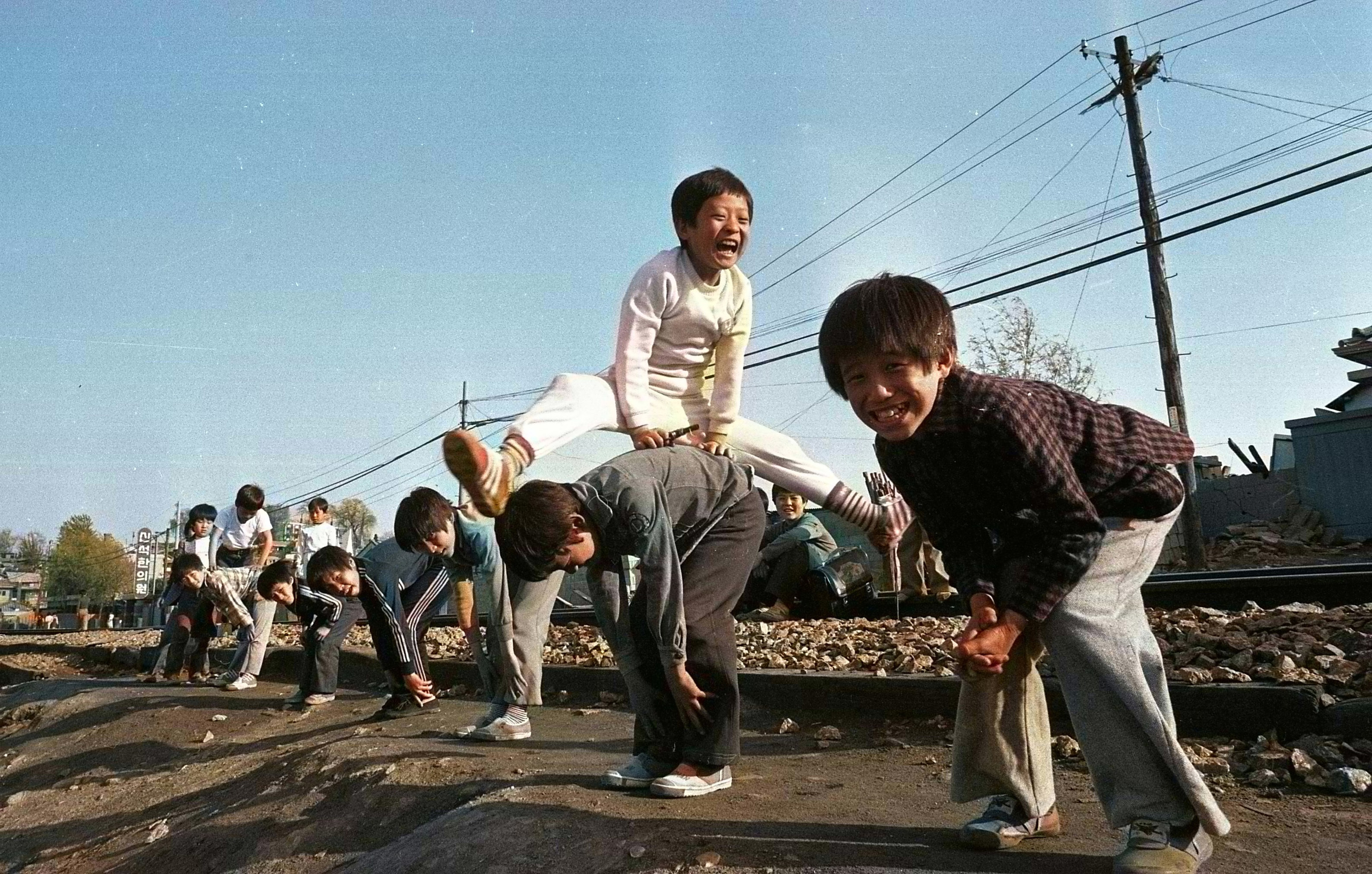 1979년 서울의 한 기찻길 옆에서 등넘기를 하고 있는 어린이들의 모습. 서울신문 DB에서 찾은 흑백사진을 컬러사진으로 복원했다. 서울신문 멀티미디어부