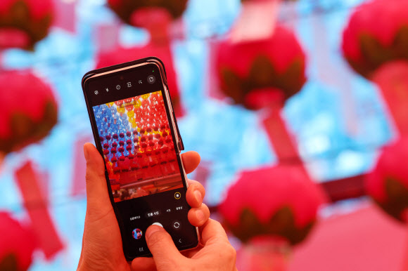 불기 2567년 부처님오신날인 27일 오후 서울 종로구 조계사를 찾은 시민이 스마트폰으로 연등을 촬영하고 있다. 2023.5.27 연합뉴스