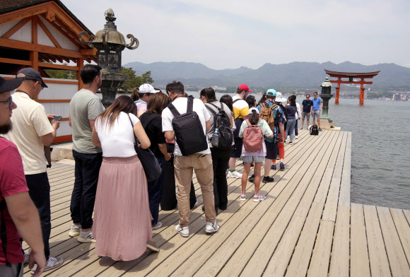 일본 서부 히로시마만(灣) 미야지마 섬에 있는 이쓰쿠시마 신사에서 관광객들이 사진을 찍기 위해 줄을 서 있다. 2023.5.22 EPA 연합뉴스