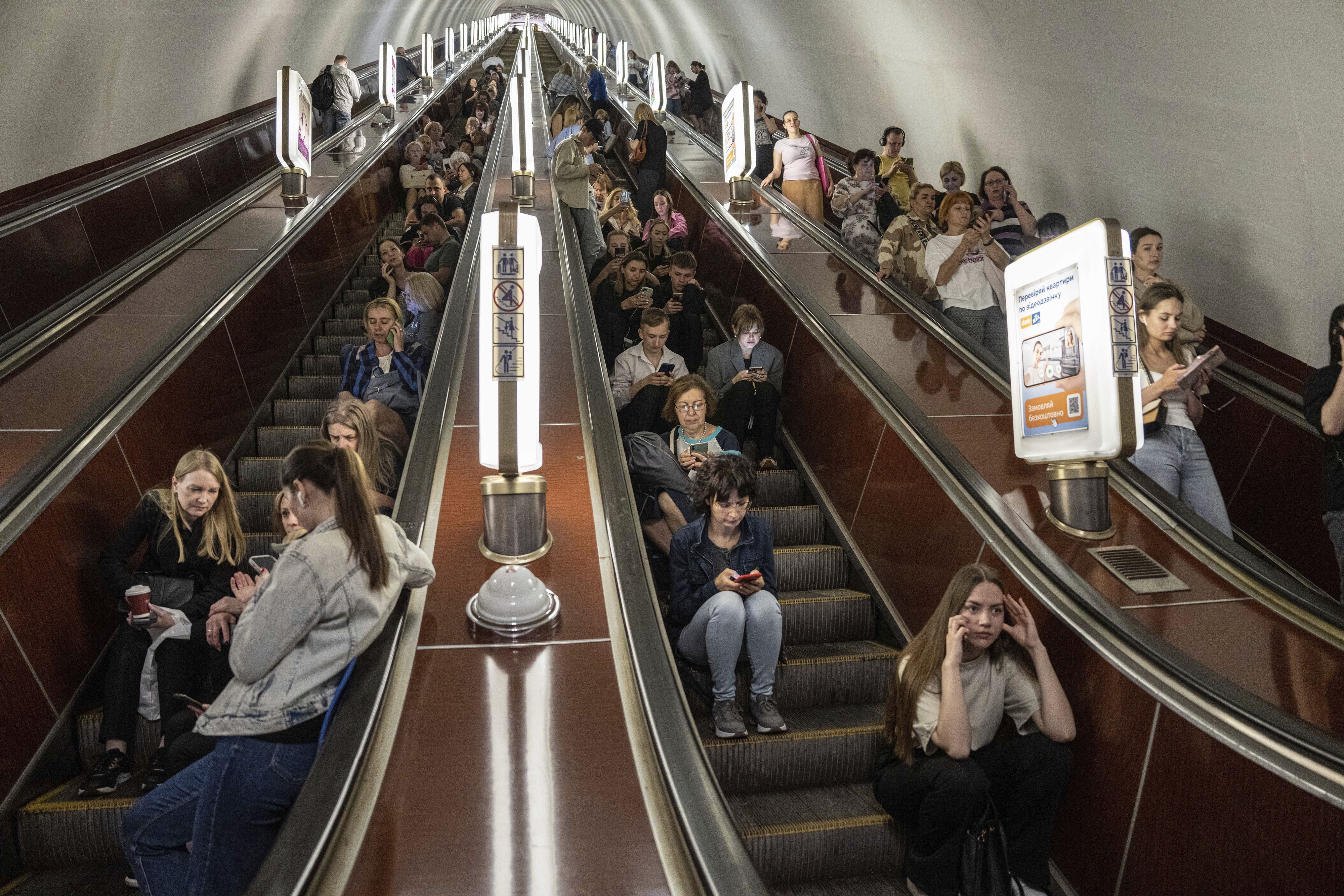 러시아가 연이틀 우크라이나 수도 키이우를 겨냥해 100기 이상의 대규모 드론 미사일 공습을 퍼부은 29일(현지시간) 지하철역으로 대피한 키이우 시민들이 에스컬레이터에 앉아 있다. 키이우 AP 연합뉴스