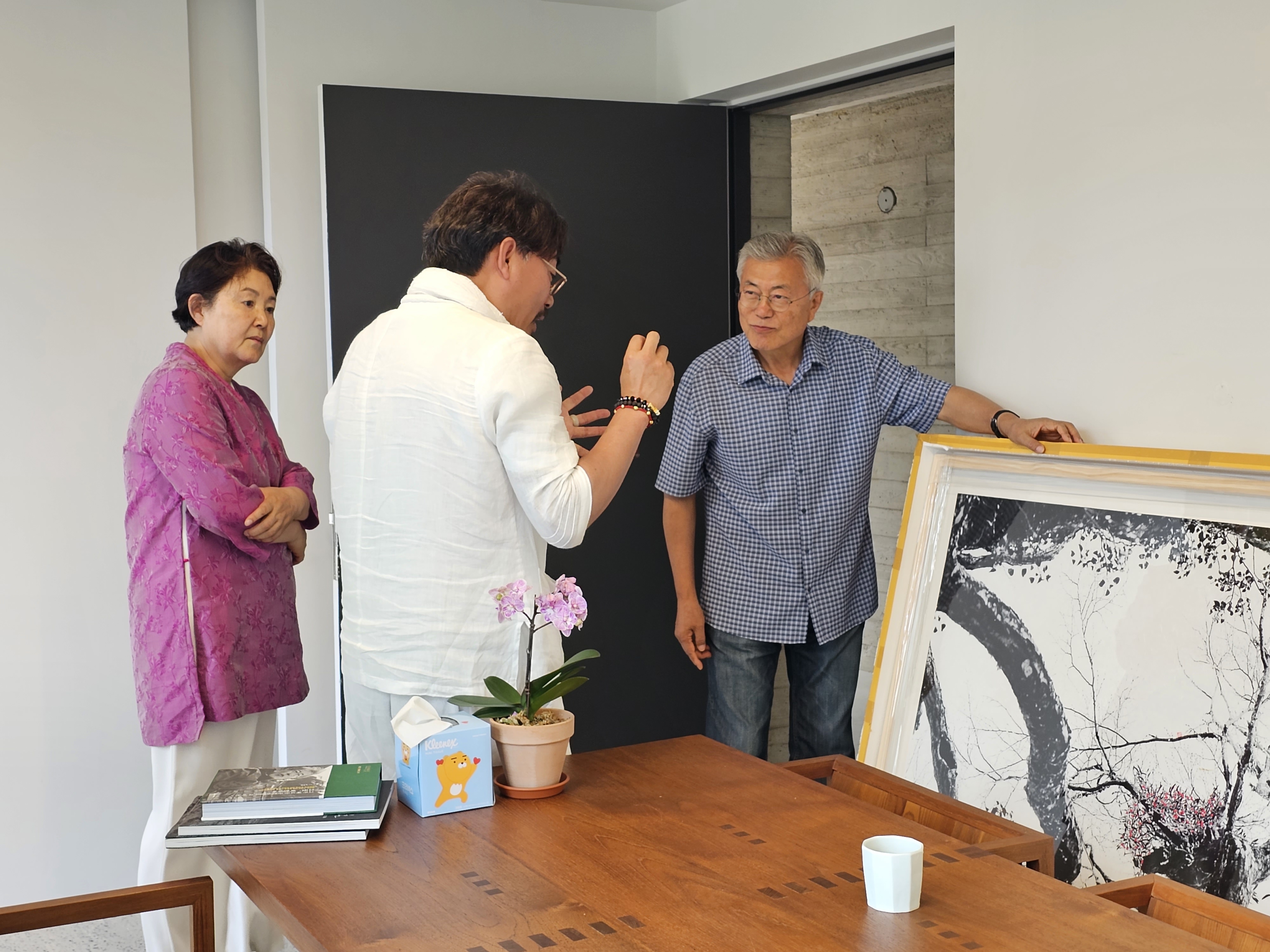 정상기(가운데) 작가가 문재인 전대통령과 김정숙 여사 앞에서 자신의 찍은 한라산 붉은겨우살이에 대한 설명을 하고 있다. 정상기 작가 제공