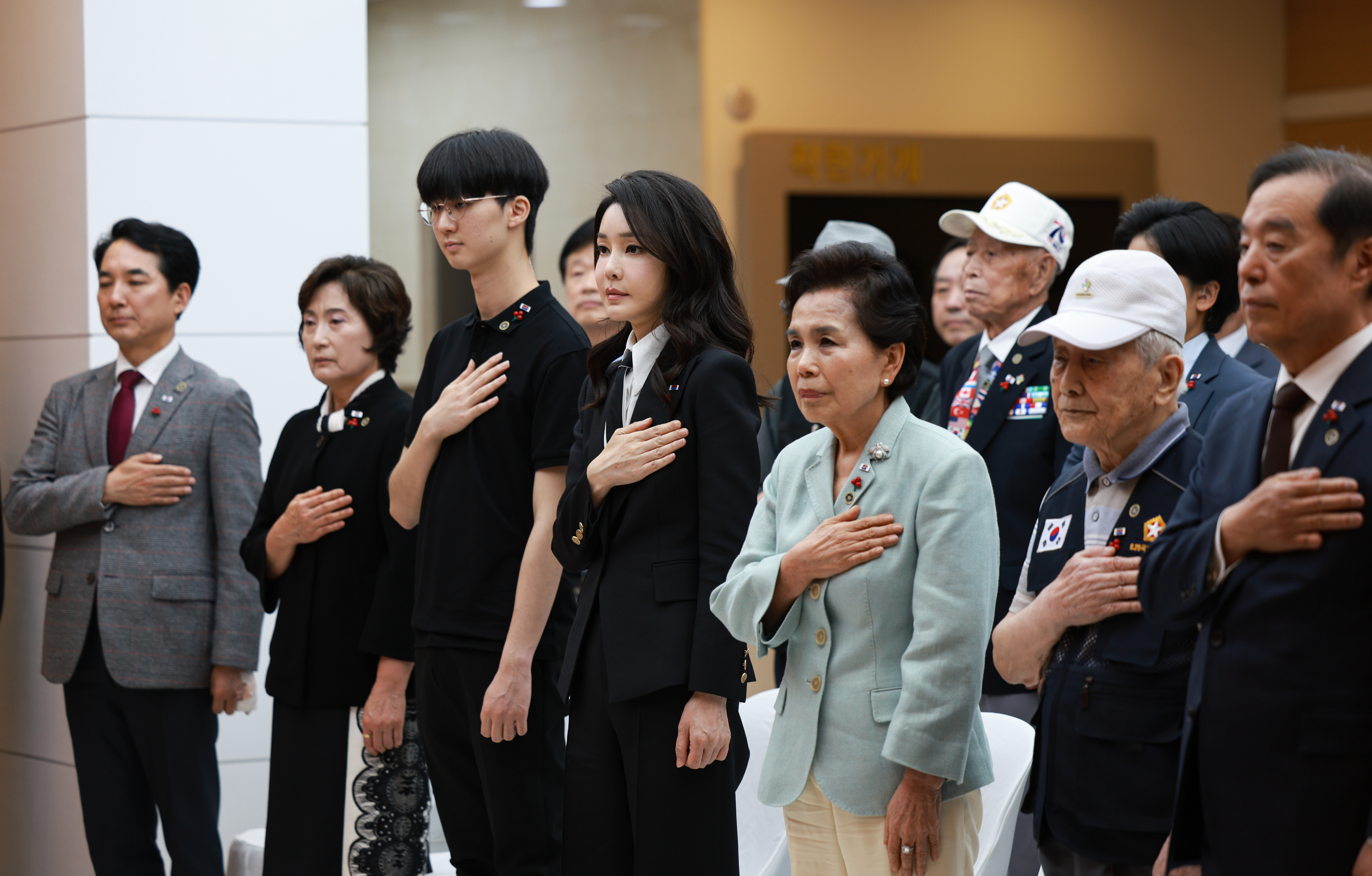 김건희(앞줄 왼쪽 네 번째) 여사가 1일 서울 중구 사랑의열매 회관에서 열린 국가유공자 지원을 위한 기부금 전달식에서 가수 이미자(다섯 번째) 등 참석자들과 함께 국기에 경례하고 있다. 연합뉴스