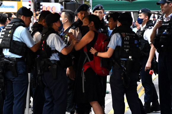 톈안먼 시위 34주년 기념일인 4일 홍콩의 쇼핑가 코즈웨이베이에서 사회민주연선의 찬포잉(붉은 색 배낭 멘 이) 주석이 경찰관과 언쟁을 하고 있다. 그는 결국 경찰에 연행됐다. 홍콩 AFP 연합뉴스