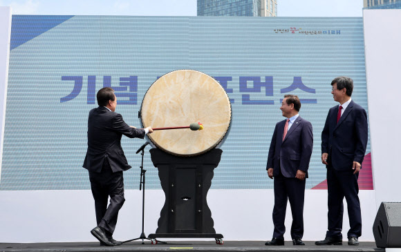 윤석열 대통령이 5일 인천 송도 센트럴파크 UN광장에서 열린 재외동포청 개청 기념행사에서 유정복 인천시장, 이기철 재외동포청장(오른쪽)과 함께 대형 북을 세번 치는 퍼포먼스를 하고 있다. 2023.6.5 연합뉴스