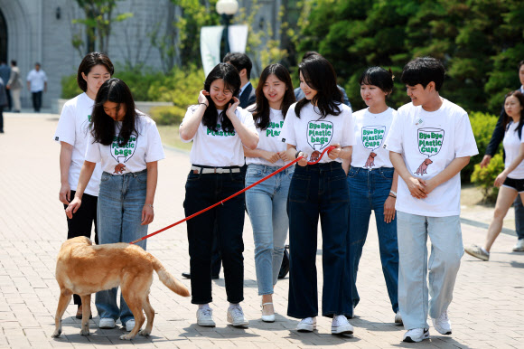 김건희 여사가 5일 서울 성북구 고려대에서 열린 ‘바이바이플라스틱(Bye Bye Plastic)’ 캠페인에서 대학생들과 함께 ‘바이바이 플라스틱’ 문구가 새겨진 티셔츠를 입고 캠페인 활동을 하고 있다. 2023.6.5. 대통령실 제공