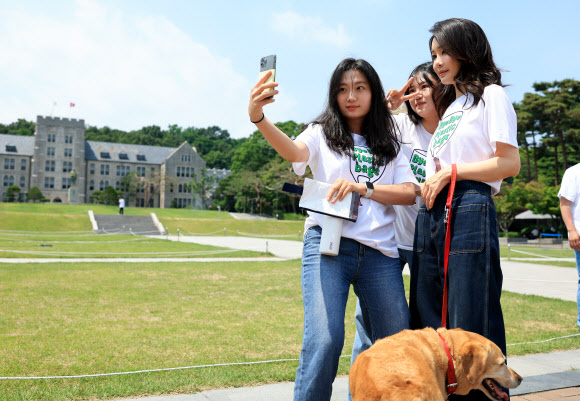 ‘바이바이 플라스틱’ 캠페인에 참여한 김건희 여사가 5일 서울 성북구 고려대 중앙광장에서 플라스틱 절감 실천을 약속한 학생들에게 폐현수막 업사이클링 파우치와 캠페인 배지를 전달한 뒤 함께 기념 촬영을 하고 있다.  2023.6.5. 대통령실 제공