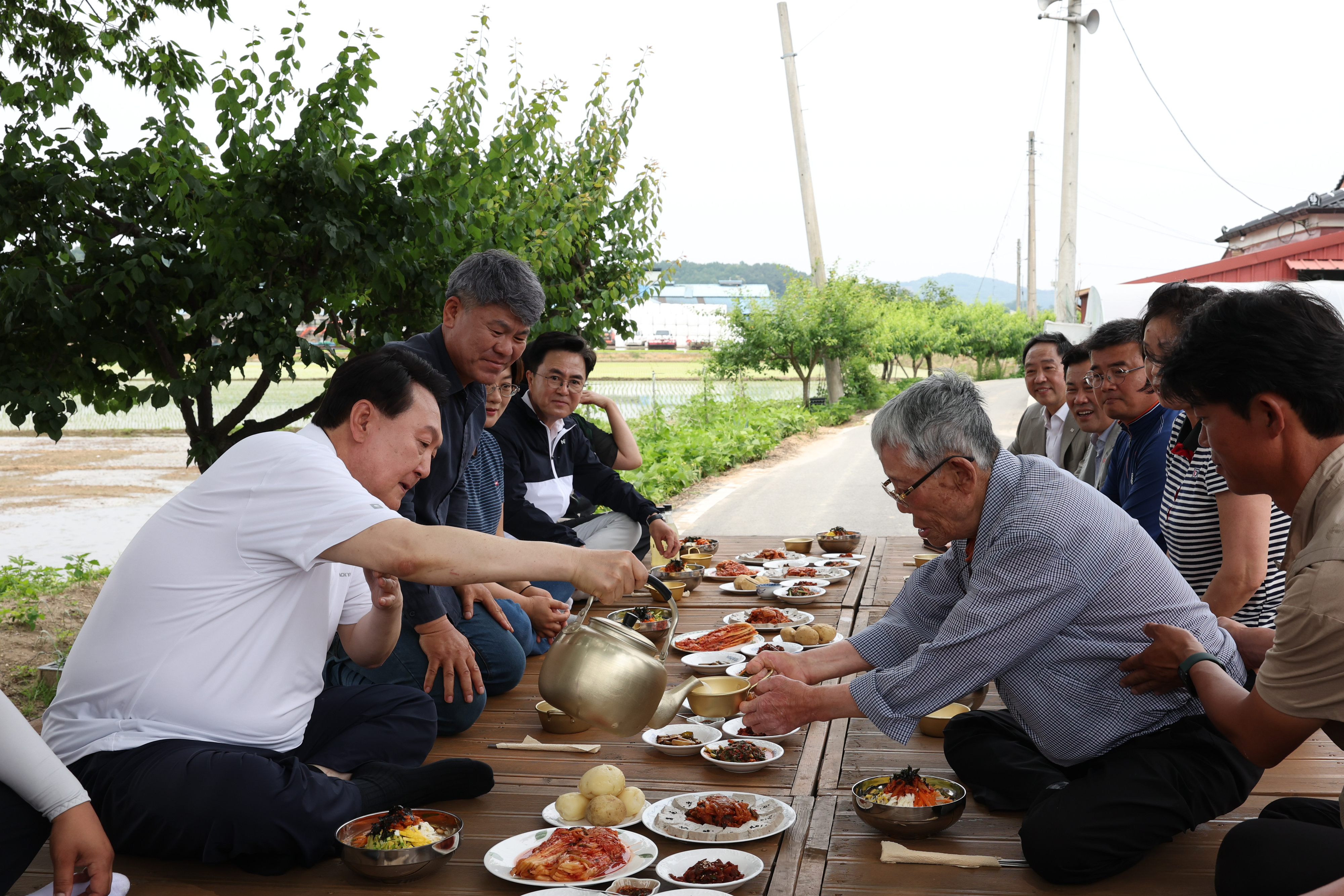 윤석열 대통령이 7일 충남 부여군 임천면에 있는 꿈에영농조합법인 모내기 현장을 방문해 직접 모내기에 참여한 뒤 주민들과 새참을 먹고 있다. 2023.6.7 대통령실 제공