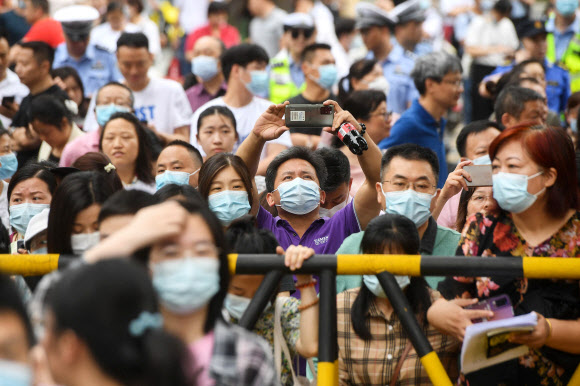 중국의 대학 입학시험인 가오카오(高考)가 시작되는 7일 후베이성 우한의 한 학교 밖에서 학부모들이 기다리고 있다. 작년 말 ‘위드 코로나’로 전환된 후 첨 치러지는 올해 가오카오는 8일까지 이틀간 진행된다. 2023.06.07. AFP 연합뉴스