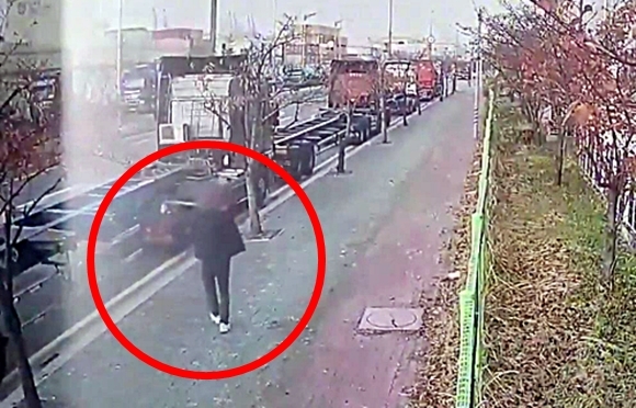 지난해 11월 26일 화물연대 조합원 중 한 명이 부산 강서구 부산신항 인근에서 도로를 향해 쇠구슬을 쏘는 모습. 부산경찰청 제공