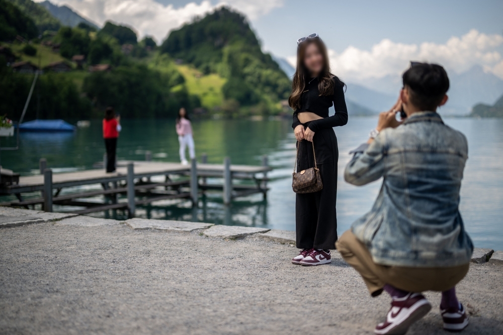 관광객이 지난 2일 스위스 알프스의 브리엔츠 호수 기슭에 있는 이젤발트 마을 부두 옆에서 사진을 찍고 있다. AFP 연합뉴스