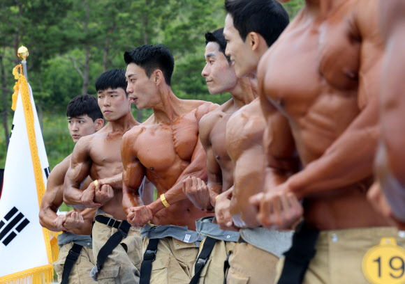 13일 충남 공주 사곡면 중앙소방학교에서 열린 제36회 전국소방기술경연대회에서 몸짱 소방관 부문에 참여한 소방관들이 멋진 근육을 선보이고 있다. 2023.6.13 연합뉴스