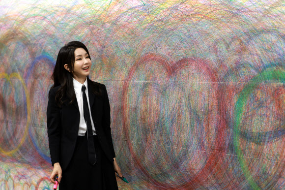 김건희 여사가 13일 광주 북구 광주비엔날레 전시관에서 진행 중인 제14회 광주비엔날레를 찾아 이건용 작가의 ‘바디스케이프76-3’을 관람한 뒤 벽면 드로잉에 직접 참여하고 있다.  2023.6.13. 대통령실 제공