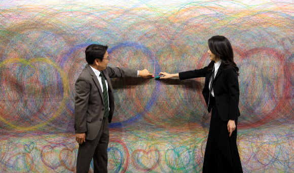 김건희 여사가 13일 광주 북구 광주비엔날레 전시관에서 진행 중인 제14회 광주비엔날레를 찾아 강기정 광주시장과 함께 이건용 작가의 ‘바디스케이프76-3’을 관람한 뒤 벽면 드로잉에 직접 참여하고 있다.  2023.6.13. 대통령실 제공