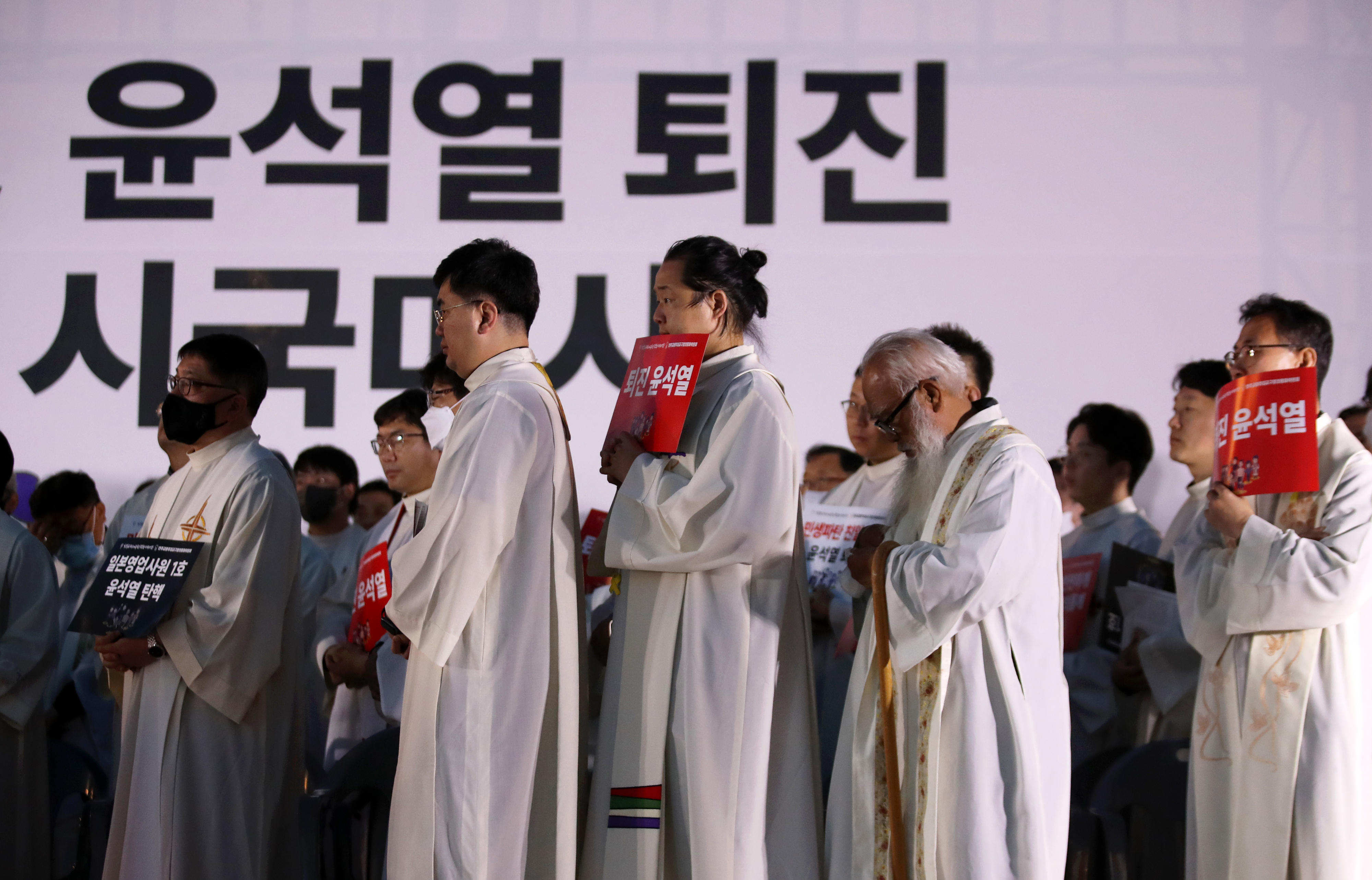 천주교정의구현사제단이 지난달 광주 동구 5·18민주광장에서 열린 친일매국 검찰독재 윤석열 퇴진과 주권회복을 위한 월요 시국 기도회에서 손팻말을 들고 있다. 광주 연합뉴스