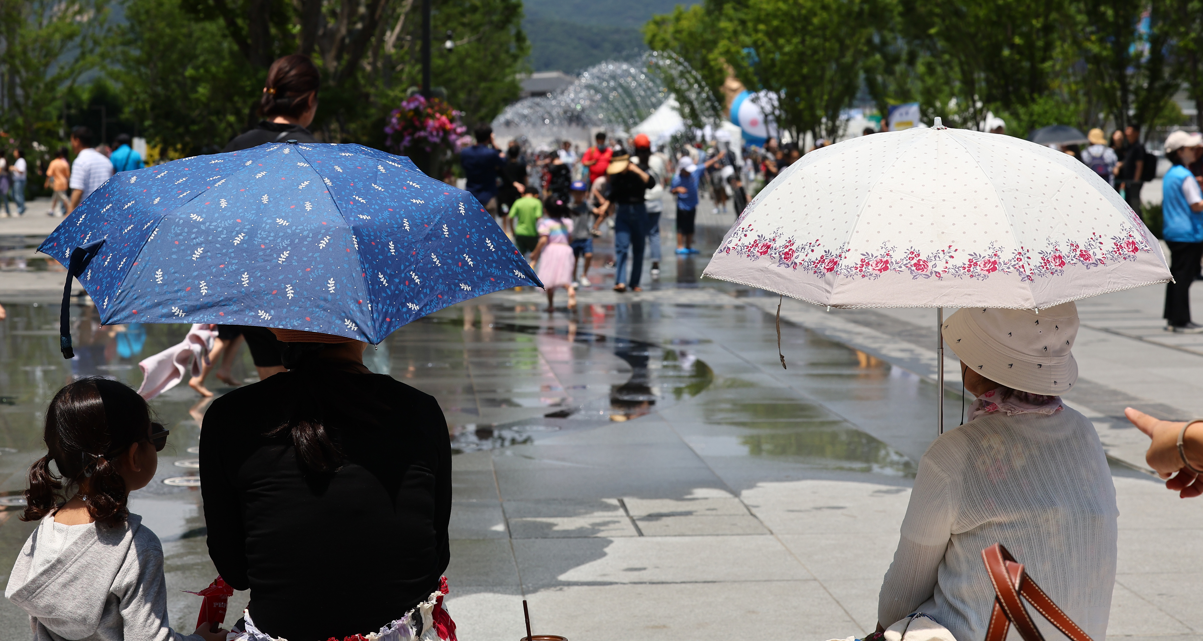 서울 종로구 광화문광장에서 양산을 쓴 시민들이 휴식하고 있다.