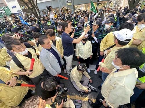 지난 17일 오전 대구 중구 반월당역 인근에서 퀴어문화축제 측 무대차량 진입을 위해 교통 정리에 나선 경찰관들과 이를 막으려는 대구시 공무원들이 대치하고 있다. 연합뉴스