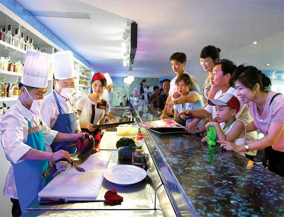 북한 대외선전매체 내나라는 18일 평양 대동강 수산물식당을 소개했다. 매체는 3층짜리 이 식당 연건평이 수만㎡에 달한다며 “산물고기료리를 이채로운 봉사환경에서 맛볼수 있는것으로 하여 많은 손님들로 흥성이고있다”고 전했다. 1층에 있는 즉석봉사식사실에서는 손님이 수산물을 직접 고르면 즉석에서 요리로 가공되며, 2층에는  민족요리식사실, 가족식사실, 동양요리식사실, 서양요리식사실 등이 갖춰져있다.2023.6.18. ‘내나라’ 홈페이지 캡처