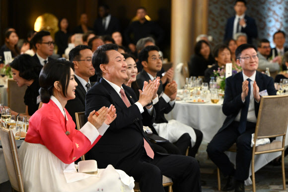 프랑스를 방문 중인 윤석열 대통령과 김건희 여사가 19일(현지시간) 파리의 한 호텔에서 열린 프랑스 동포 초청 만찬 간담회에서 ‘한국의 마음’ 합창단의 공연을 관람하며 박수치고 있다. 2023.6.20. 공동취재
