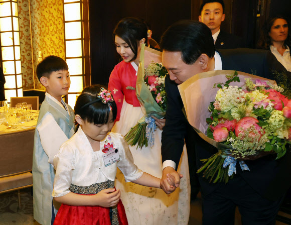프랑스를 방문 중인 윤석열 대통령과 김건희 여사가 19일(현지시간) 파리의 한 호텔에서 열린 프랑스 동포 초청 만찬 간담회에서 화동으로부터 꽃다발을 받고 있다. 2023.6.20 연합뉴스
