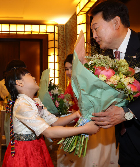 프랑스를 방문 중인 윤석열 대통령과 김건희 여사가 19일(현지시간) 파리의 한 호텔에서 열린 프랑스 동포 초청 만찬 간담회에서 화동으로부터 꽃다발을 받고 있다. 2023.6.20 연합뉴스
