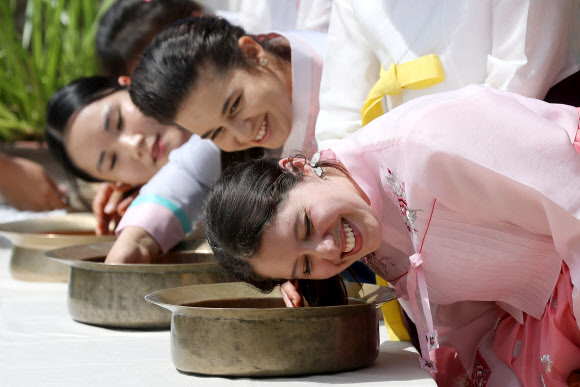 음력 5월 5일 전통 명절 단오를 이틀 앞둔 20일 오전 경북 경산시 영남대학교 민속촌에서 외국인 유학생들이 창포물에 머리감기 체험을 하고 있다. 예부터 단오에 창포를 삶은 물로 머리를 감으면 창포 특유의 향기로 나쁜 귀신을 쫓고, 머리에 윤기가 난다고 믿었다. 2023.6.20 연합뉴스