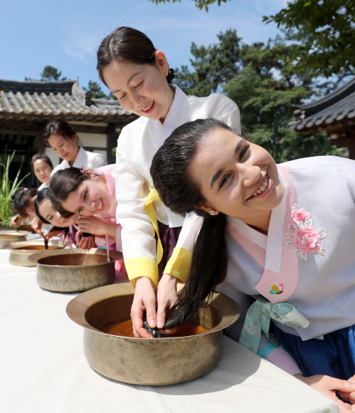 음력 5월 5일 전통 명절 단오를 이틀 앞둔 20일 오전 경북 경산시 영남대학교 민속촌에서 외국인 유학생들이 창포물에 머리감기 체험을 하고 있다. 예부터 단오에 창포를 삶은 물로 머리를 감으면 창포 특유의 향기로 나쁜 귀신을 쫓고, 머리에 윤기가 난다고 믿었다. 2023.6.20 연합뉴스